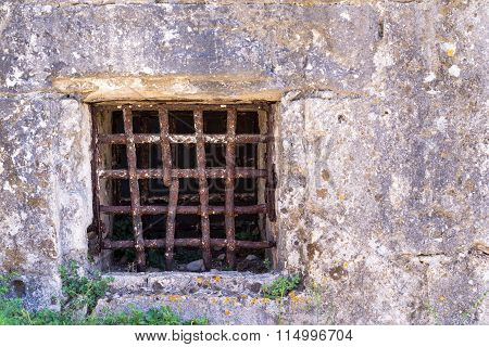 Old Window With A Rusty Grating On Ancient Wall