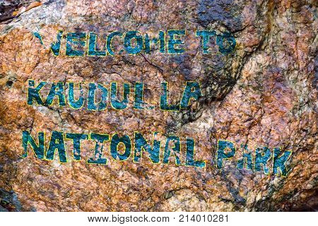 Welcome words written on stone at the entrance to Kaudulla National Park, Sri Lanka