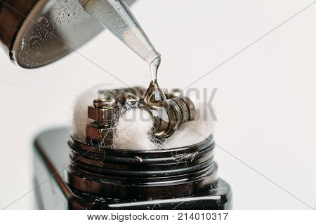 RDA atomizer for vaping or e-cigarette with Alien Clapton coil, process of dripping with e-liquid or e-juice, modern vape device for quit smoking, macro photo with selective focus
