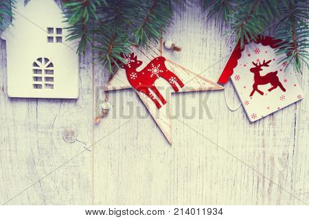 Christmas background. Christmas trees and Christmas decorations are on old light boards. Fir branches. Handmade decorations. Toned image. Space for text.