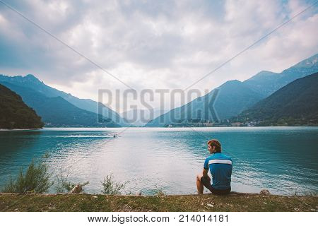 Man Cyclist Rests Near A Mountain Lake Lago Di Ledro In Italy