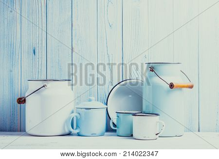 Enamelware on the kitchen table over blue wooden wall