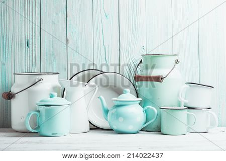Enamelware on the kitchen table over blue wooden wall