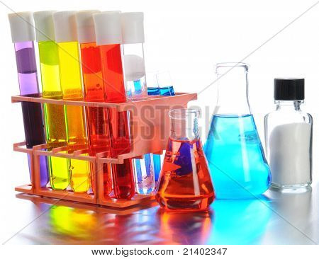 Acercamiento de equipo de laboratorio científico sobre una superficie metálica brillante. Llenan tubos de ensayo, vasos y frascos