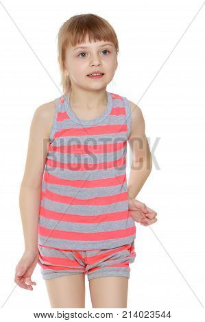 Beautiful little caucasian girl with a short bangs and hair tucked into a tail. In striped in a T-shirt and shorts.