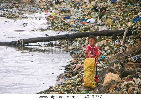 Labuan Bajo, Indonesia-march 17: Unidentified Boys Go Through Garbage At Sea Coast On March 17,2012