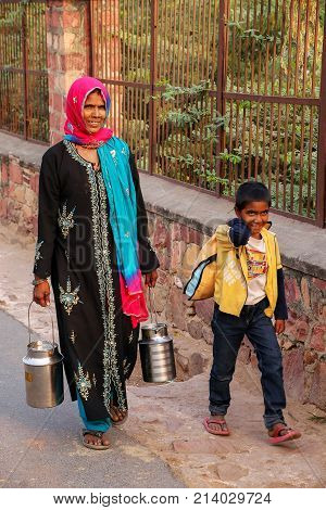 Fatehpur Sikri, India-november 9: Unidentified Woman With A Boy Carries Milk Jugs In The Street On N