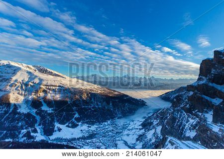Leukerbad view from Gemmipass in evening sun and sea of fog clouds blue sky