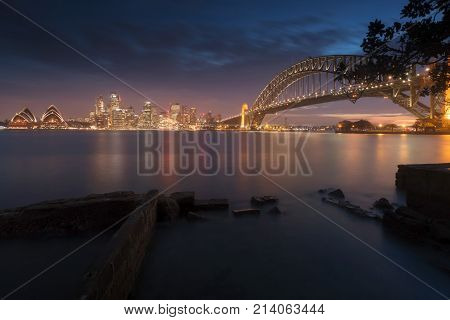 Night city, Cityscape view of Sydney bay with buildings and harbour bridge at night.