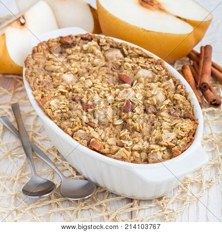 Baked oatmeal with nuts almond milk honey spices and pear square format