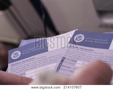 NYC - OCTOBER 2017: Tourist Filling up U.S. Customs Declaration Forms On A Plane Before Entering The United States of America