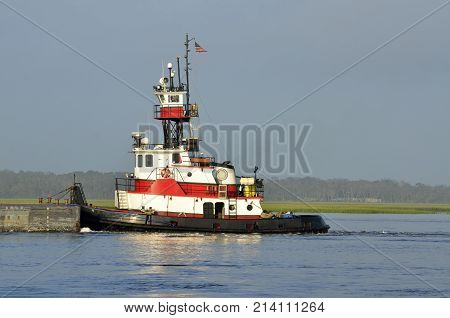 Tug boat pushing a barge on the river at St. Augustine, Florida