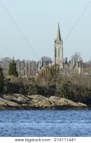 New Bedford Massachusetts USA - November 15 2017: St. John the Baptist Church with Acushnet River and Palmer's Island in foreground in New Bedford Massachusetts