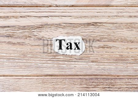 Tax of the word on paper. concept. Words of Tax on a wooden background.