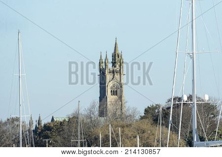 Fairhaven Massachusetts USA - November 15 2017: Tower of Unitarian Church looms over boat masts at marina in Fairhaven Massachusetts