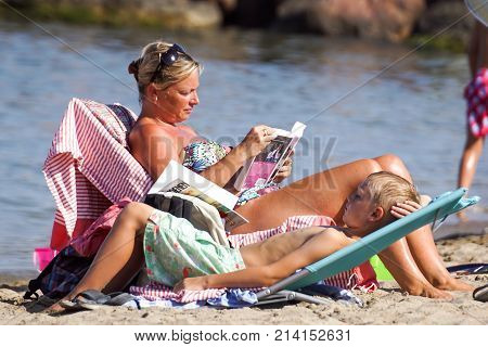 Nice , France - 5 august 2017 : Rear view of woman relaxing and read a book on the beach
