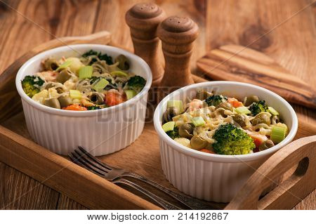 Casserole with vegetbales and cheese on wooden background..