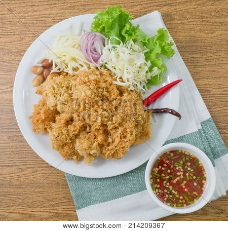 Thai Cuisine and Food Top View of Thai Traditional Crispy Catfish Salad Served With Green Oak Shredded Green Mango Red Onion Cabbage Chili Peanut and Spicy Sauce.