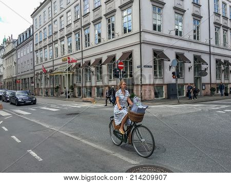 COPENHAGEN DENMARK - JUNE 2016: Young women riding on bike in Copenhagen street