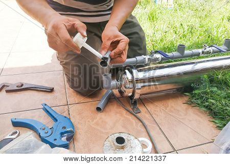 Series Of Plumber Fixing Up Ourdoor Water Filter With Pvc Piping