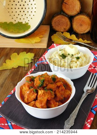 Meat stewed in tomato sauce. Porkolt, Hungarian cuisine meal. Nokedli, a type of egg noodle in the background