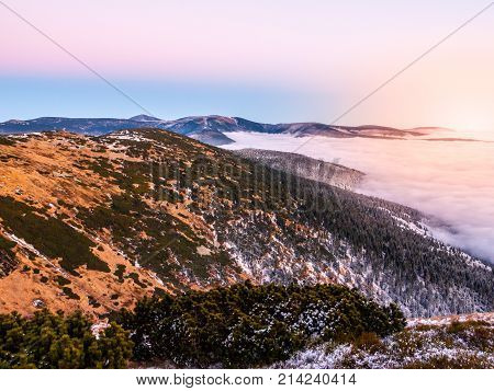 Mountain landscape at sunset time. Freezy evening and weather inversion, Giant Mountains, aka Krkonose, Czech Republic.