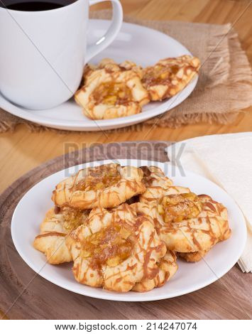 Apple caramel cokies on a plate with cup of coffee in background
