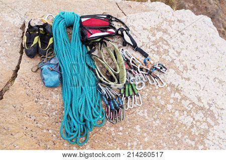 Climbing equipment - bag for magnesia rope and carbines view from the top close-up. A coiled climbing rope lying on the ground as a background. Concept of outdoor sport