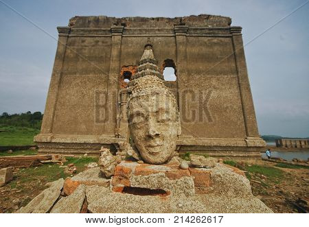 Buddhist monk head arts in front of underwater temple in Thailand