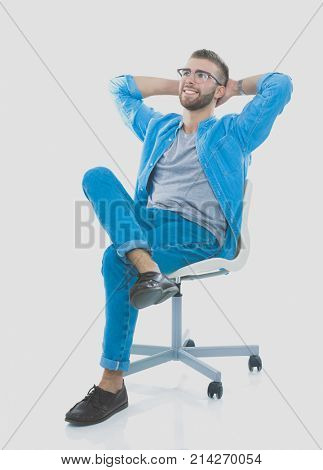Young man sitting on the chair isolated over white background. Startupper. Young entrepreneur.