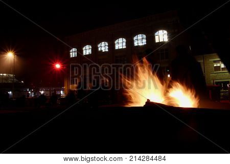 Wood fire burning during a busy street festival.