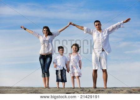 happy young family have fun on beachand showing home sign with conncected hands while protecting childrens