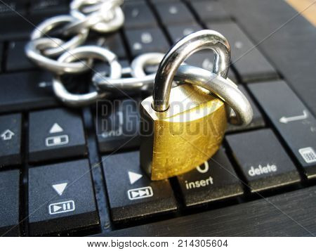 Chain with lock on computer keyboard. It means laptop banned or internet banned. Symbol of computer addiction, games, social networks, block chain for crypto currency and so on