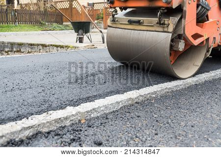 Sidewalk asphalt and compact with a road roller - close-up