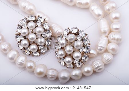 Pearl necklace and pearl earrings on a white background