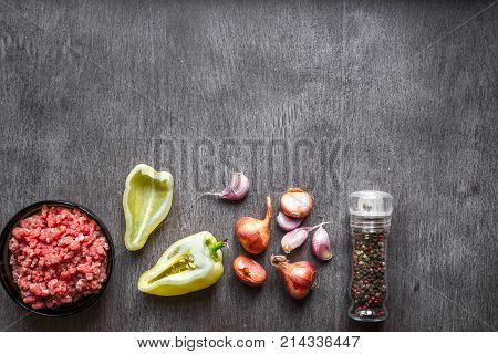 Composition of raw meat with vegetables and spice on wooden background. Top view. Copy space. Still life. Flat lay.