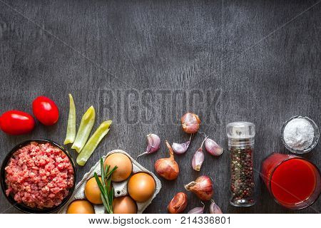 Composition of raw meat with vegetables and spice on wooden background. Top view. Copy space. Still life. Flat lay.