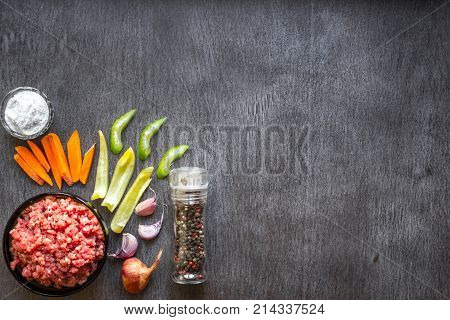 Composition of raw meat with vegetables and spice on wooden background. Top view. Copy space. Still life. Flat lay.