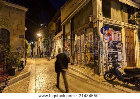 ATHENS GREECE - NOVEMBER 3 2017: building corner in Psyri district of Athens' city center left to decay and ruin with people walking in the dark