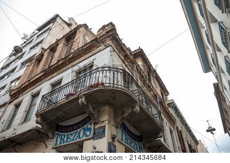 ATHENS GREECE - NOVEMBER 4 2017: building corner in Psyri district of Athens' city center left to decay and ruin with a balcony on foreground