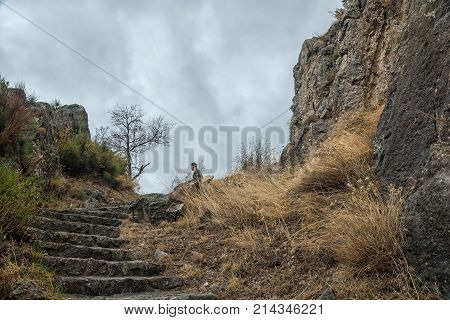 Traveler man relaxing upstairs at the foot of ancient castle. travel lifestyle concept summer vacations outdoor. Castle Klis Croatia
