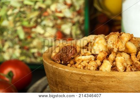 Heap of domestic salty fried pork greaves. Fatty junk food. Pork greaves on the kitchen board
