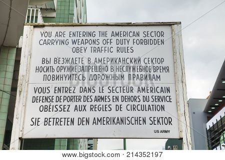 BERLIN - AUGUST 21 2017: Historical sign at Checkpoint Charlie on August 21 2017 in Berlin Germany. The name was given by the Western Allies to the best-known Berlin Wall crossing point between East and West Berlin.