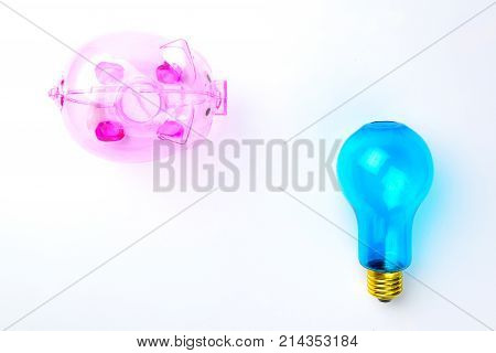 Pinnk Piggy Bank and blue bilb on white background for thinking money saving concept.