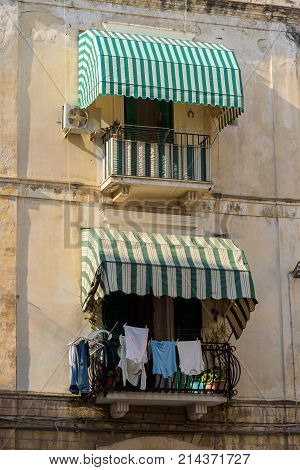 Traditional balconies with awnings and hanging laundry in Bari Apulia Italy
