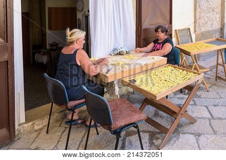 Bari Italy - September 2 2016: Women maki traditional italian pasta called orecchiette on the street of old town of Bari