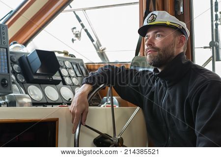 Captain at the helm of a boat going along the Pacific Ocean