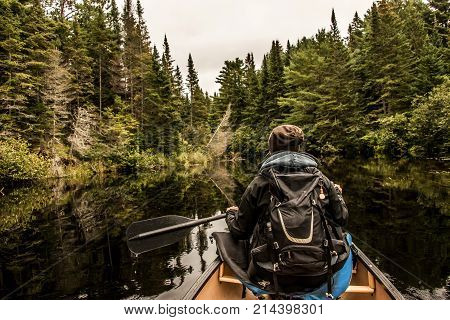Girl canoeing with Canoe on the lake of two rivers in the algonquin national park in ontario Canada on a cloudy day