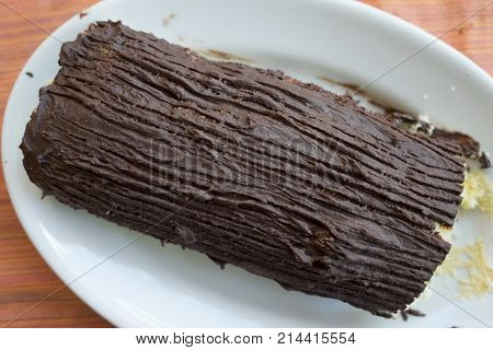 chocolate yule log cake with stuffing of cream and candied