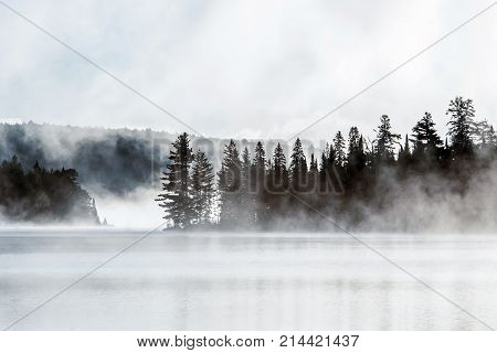 Lake of two rivers in algonquin national park ontario canada sunset sunrise with fog foggy mystical atmosphere background